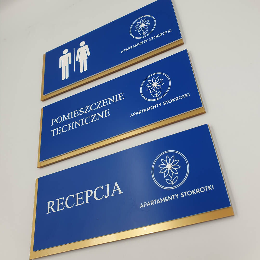 Personalizowana numeracja pokoi i pomieszczeń z niebieskiego laminatu grawerskiego na złotym akrylu